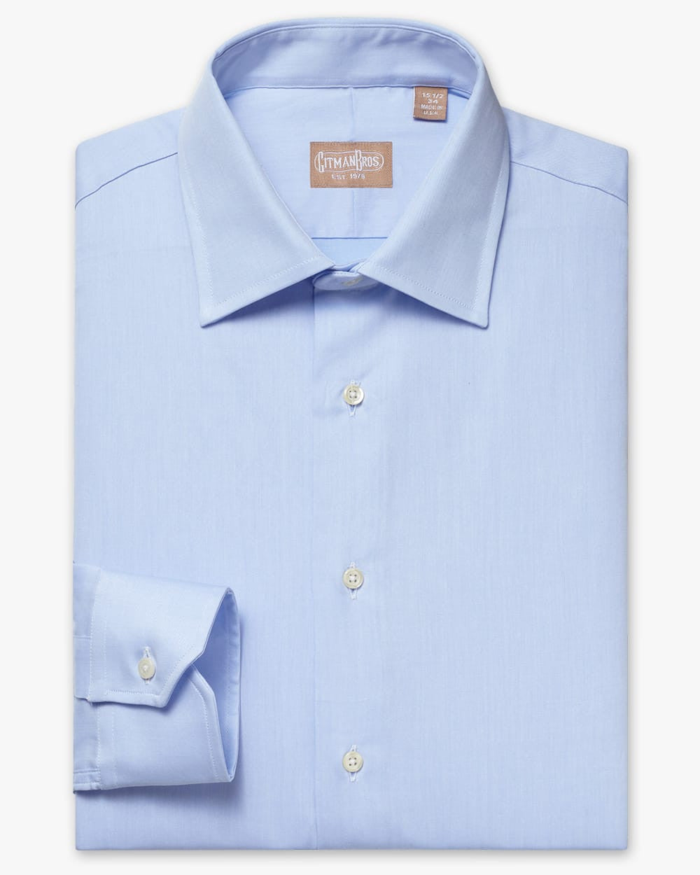 a folded medium spread shirt with white buttons made from solid blue twill fabric