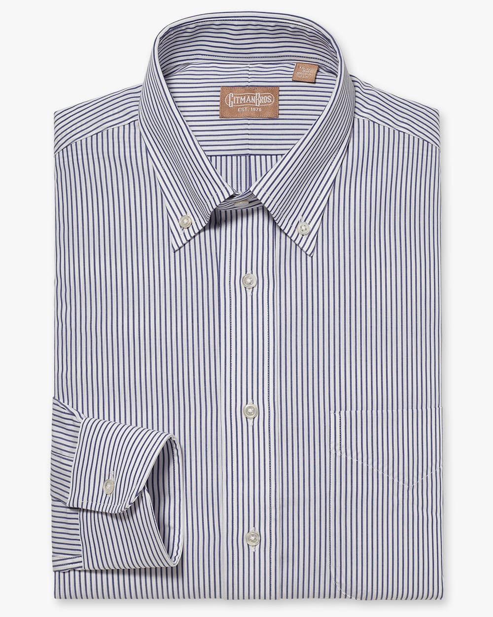 a folded button down shirt with white buttons made from navy blue bengal stripe fabric