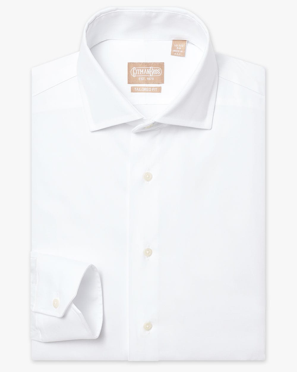 a folded wide spread collar shirt with mitered cuff and white buttons made from solid white pinpoint fabric
