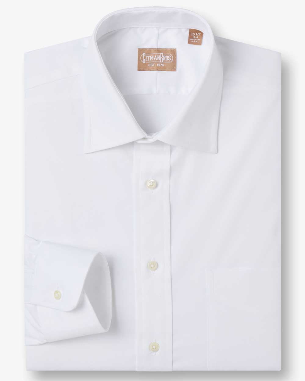 a folded medium spread shirt with white buttons made from solid white fabric