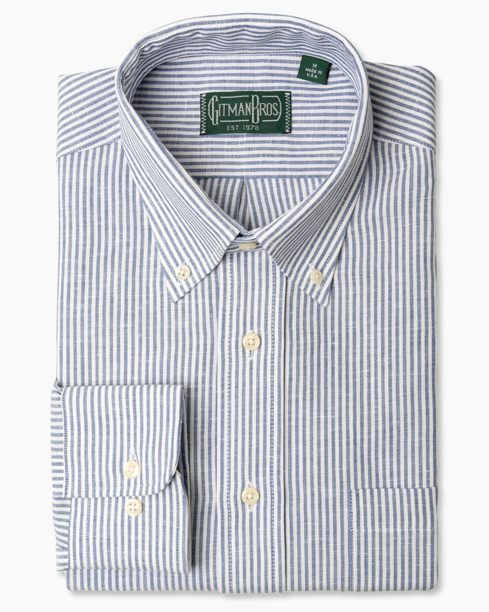 The Blue Stripe Linen sport shirt, with a button down collar and adjustable cuffs with white buttons on them.