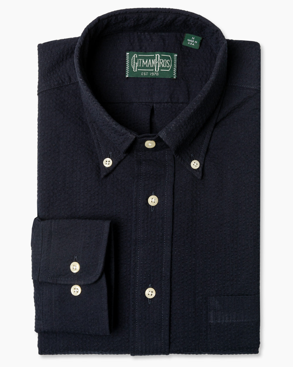 The Navy Overdye Seersucker sport shirt, with a button down collar and adjustable cuffs with white buttons on them.