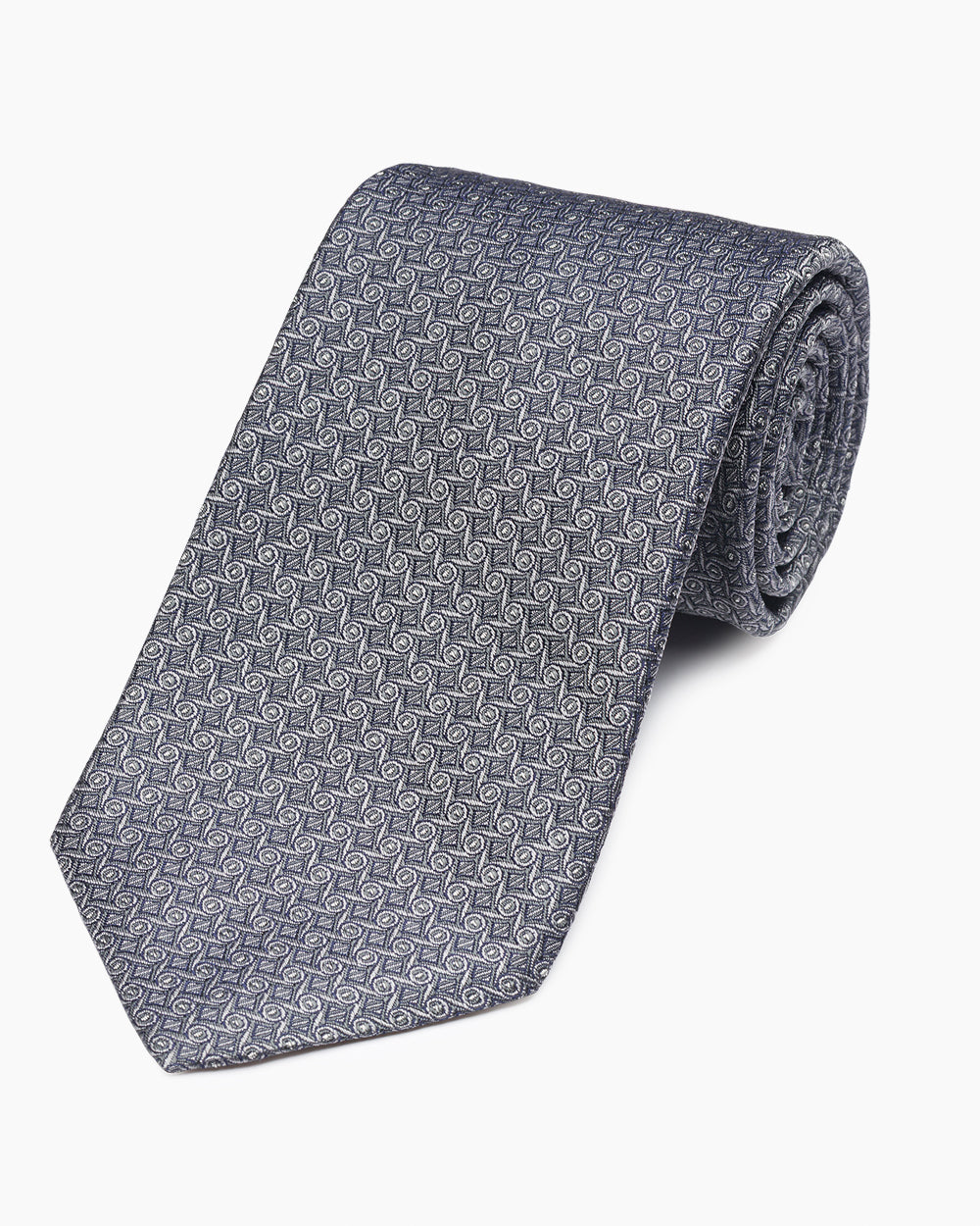The Grey Woven Wave Tie, crafted from 100% silk and hand-sewn in North Carolina. A subtle textured pattern with a natural drape, designed for versatile, refined tailoring.