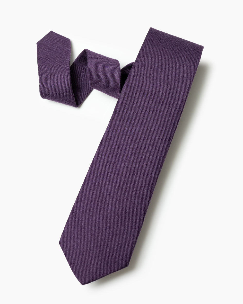 The purple wool/silk tie with 70% wool and 30% silk hand sewn labels, loops and bar tack with a hand shaped form.